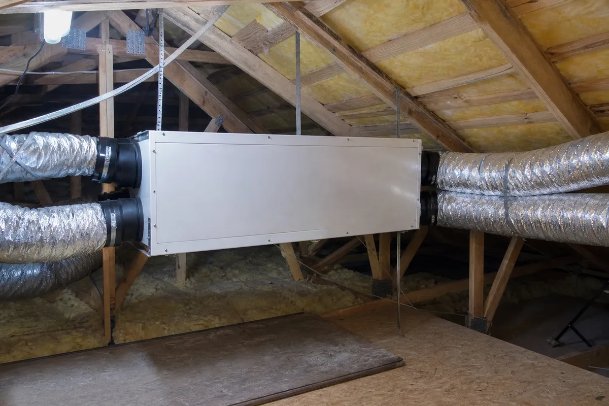 Caisson de VMC double flux avec ses gaines isolées installé dans des combles aménagés